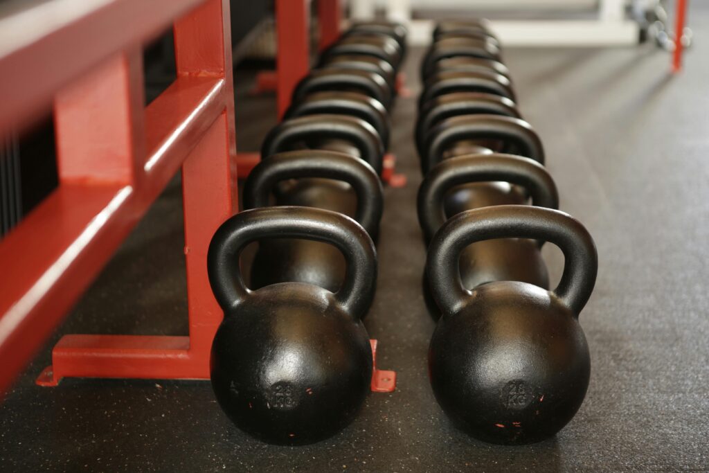Black kettlebells lined up in a gym, ready for fitness training.